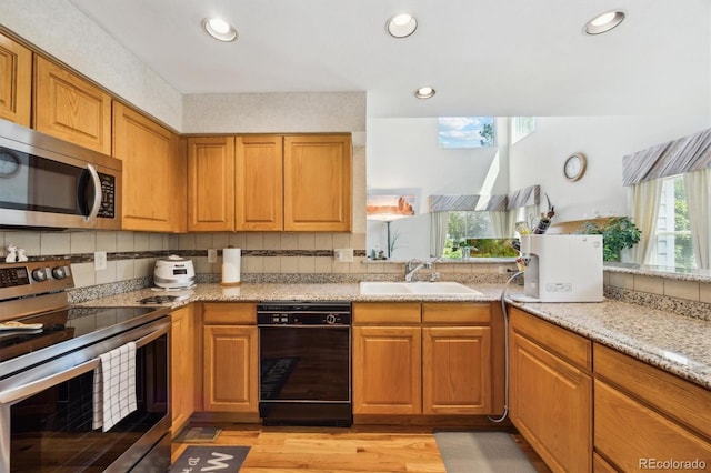5134 S Ouray Ct, Centennial, CO 80015 - kitchen featuring stainless steel appliances, a sink, light wood-type flooring, brown cabinetry, and recessed lighting