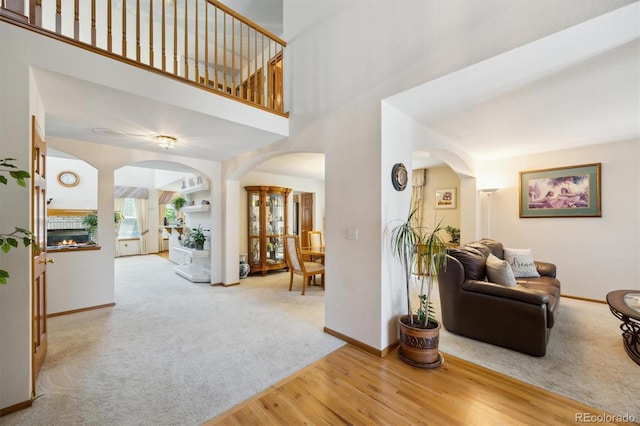 5134 S Ouray Ct, Centennial, CO 80015 - living area featuring arched walkways, baseboards, wood finished floors, carpet floors, and a high ceiling