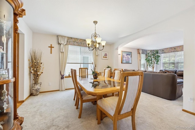 5134 S Ouray Ct, Centennial, CO 80015 - dining area with a chandelier, arched walkways, light colored carpet, and baseboards