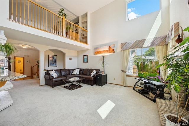 5134 S Ouray Ct, Centennial, CO 80015 - living area featuring a towering ceiling, arched walkways, healthy amount of natural light, carpet, and stairway