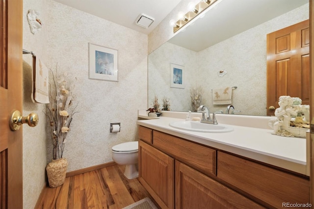 5134 S Ouray Ct, Centennial, CO 80015 - bathroom with wood finished floors, vanity, toilet, wallpapered walls, and baseboards
