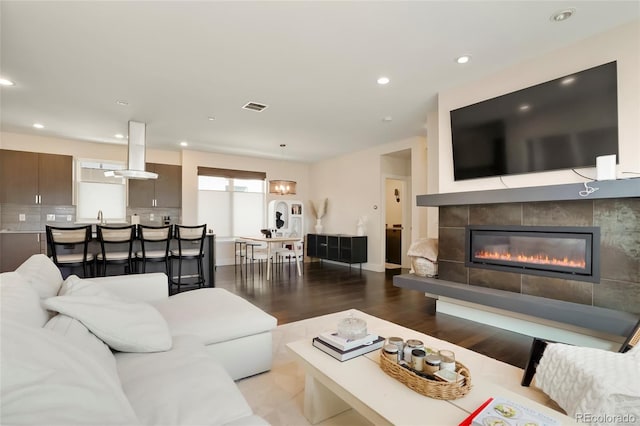 living room featuring a tile fireplace and light wood-type flooring