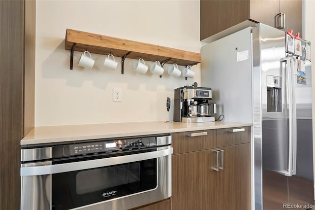 kitchen featuring oven and stainless steel fridge with ice dispenser