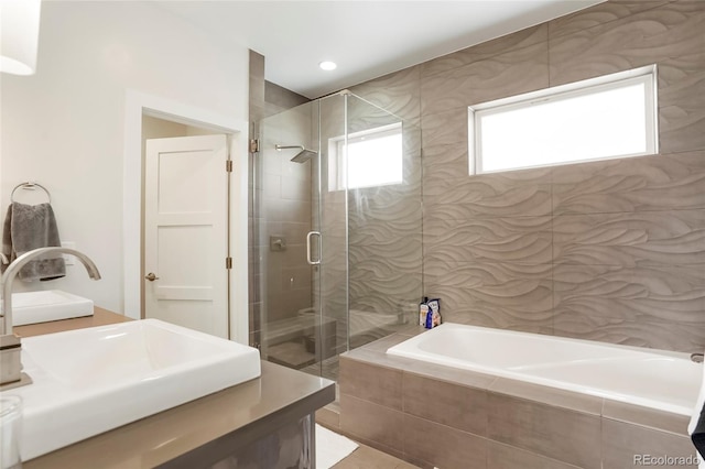 bathroom featuring vanity and shower with separate bathtub