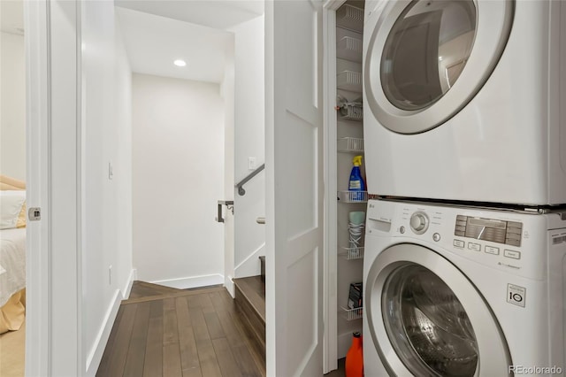 washroom with stacked washer / drying machine and wood-type flooring