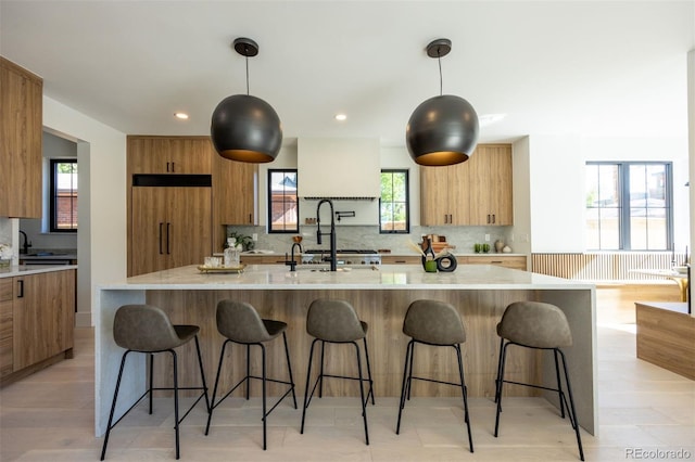 kitchen with a wealth of natural light, hanging light fixtures, and fridge