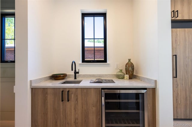 bar featuring beverage cooler, sink, and plenty of natural light