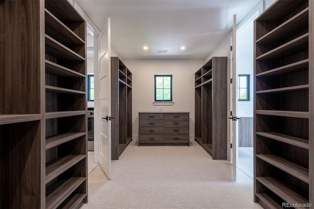 walk in closet featuring light carpet