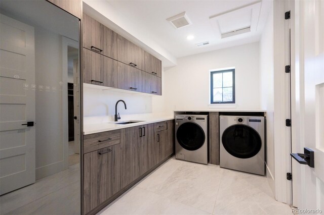 washroom with washer and clothes dryer, sink, light tile floors, and cabinets