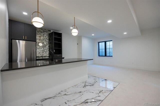 kitchen with sink, stainless steel fridge, decorative light fixtures, and light colored carpet