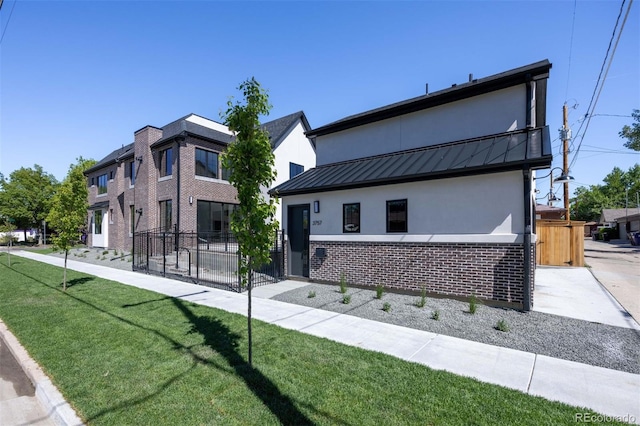 view of front of home featuring a balcony and a front lawn