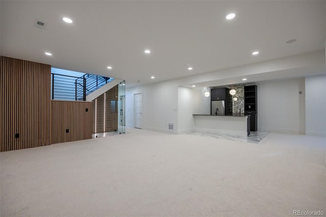 basement featuring stainless steel fridge and light colored carpet