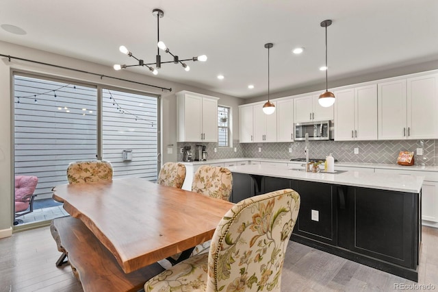5841 Alton St, Denver, CO 80238 - dining space featuring light wood finished floors, a chandelier, and recessed lighting