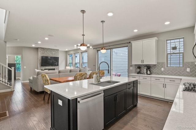 5841 Alton St, Denver, CO 80238 - kitchen with appliances with stainless steel finishes, white cabinetry, dark wood finished floors, recessed lighting, and a center island with sink