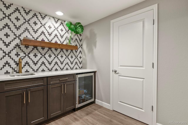 5841 Alton St, Denver, CO 80238 - indoor wet bar with beverage cooler, light wood finished floors, and backsplash