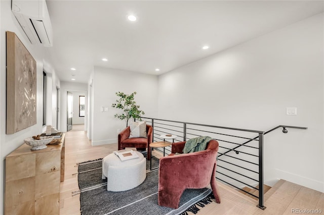 living area featuring a wall mounted AC and light wood-type flooring