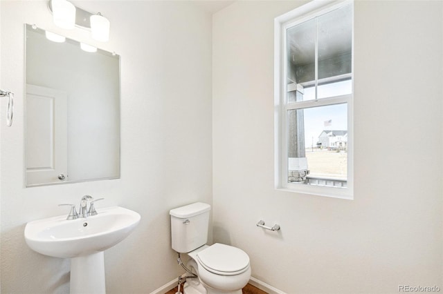 bathroom featuring a healthy amount of sunlight, sink, and toilet