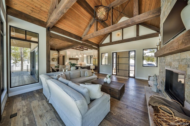 living area with a chandelier, wood ceiling, baseboards, healthy amount of natural light, and beamed ceiling