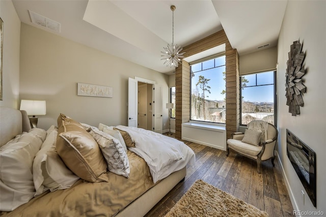 bedroom featuring a chandelier, dark wood-style floors, and baseboards
