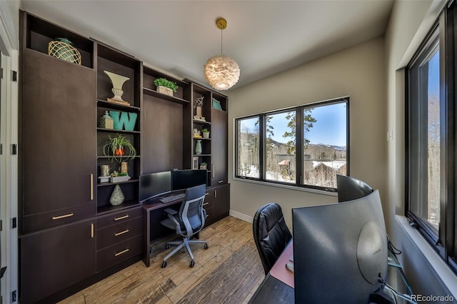 office area with light wood finished floors, healthy amount of natural light, and baseboards