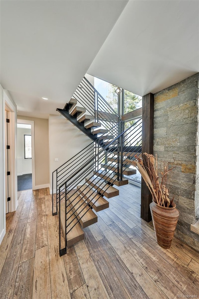staircase with wood-type flooring and baseboards