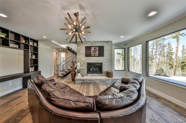 living area with baseboards, hardwood / wood-style floors, recessed lighting, a chandelier, and a fireplace