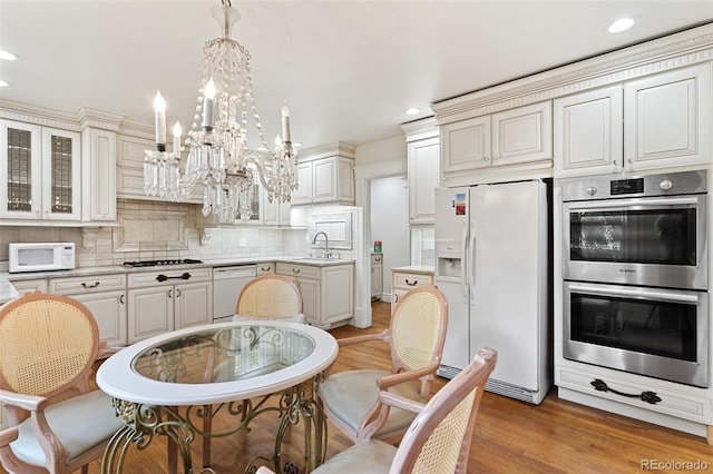 120 E Espanola St, Colorado Springs, CO 80907 - kitchen featuring white appliances, a chandelier, recessed lighting, light countertops, and light wood-type flooring