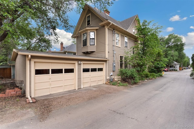 120 E Espanola St, Colorado Springs, CO 80907 - view of home's exterior with a chimney, an attached garage, and driveway