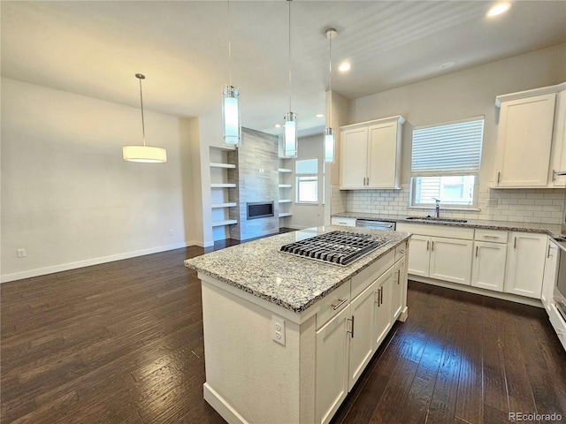 kitchen with white cabinetry, dark hardwood / wood-style floors, sink, and decorative light fixtures