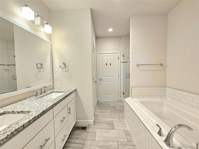 bathroom with tile patterned flooring, independent shower and bath, and dual vanity