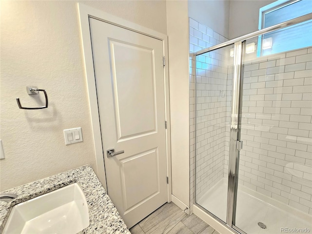 bathroom featuring a shower with door, tile patterned flooring, and vanity