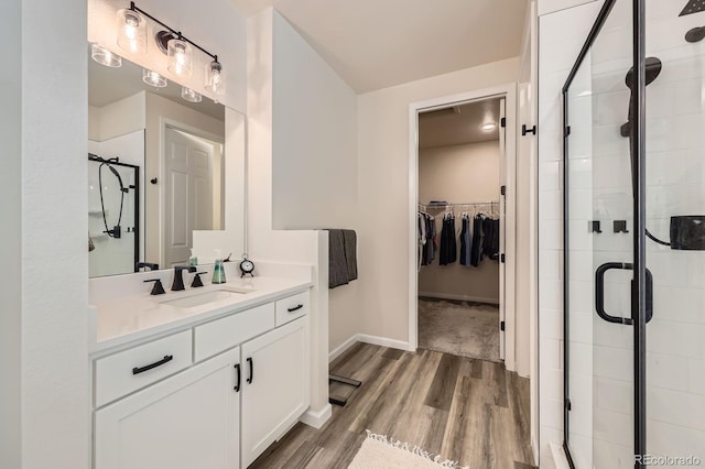 5134 Queen Ct, Arvada, CO 80002 - bathroom with a walk in closet, a shower stall, vanity, and wood finished floors