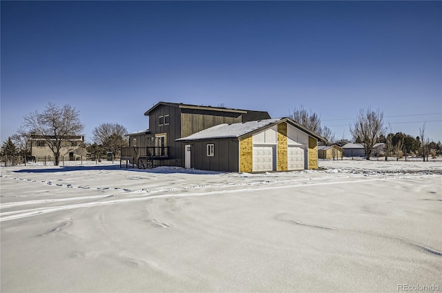 snow covered property featuring a garage