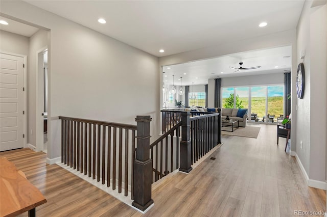 7000 S White Crow Way, Aurora, CO 80016 - hall featuring an upstairs landing, wood finished floors, and recessed lighting