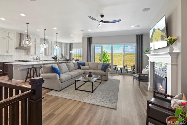7000 S White Crow Way, Aurora, CO 80016 - living room with ceiling fan, light wood finished floors, a fireplace, and recessed lighting