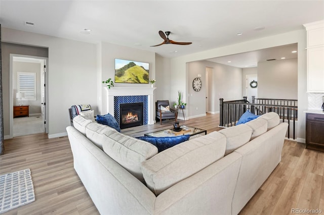 7000 S White Crow Way, Aurora, CO 80016 - living area with ceiling fan, light wood finished floors, a tiled fireplace, and recessed lighting