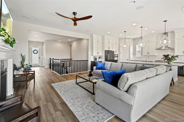 7000 S White Crow Way, Aurora, CO 80016 - living area with ceiling fan, recessed lighting, light wood-style floors, and a fireplace