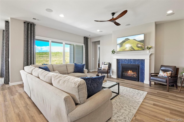 7000 S White Crow Way, Aurora, CO 80016 - living area featuring a ceiling fan, a fireplace, light wood finished floors, and recessed lighting