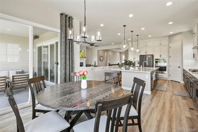 7000 S White Crow Way, Aurora, CO 80016 - dining room featuring recessed lighting, light wood-type flooring, and a chandelier