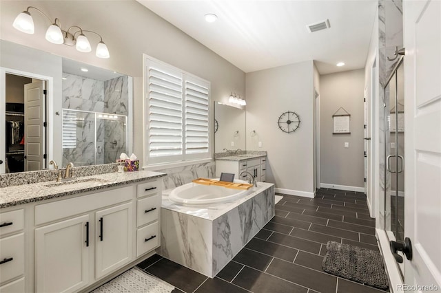 7000 S White Crow Way, Aurora, CO 80016 - full bath with a marble finish shower, a garden tub, two vanities, recessed lighting, and tile patterned flooring