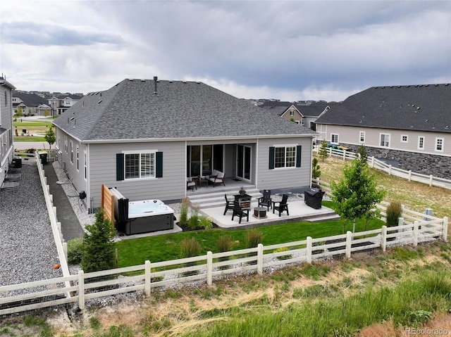 7000 S White Crow Way, Aurora, CO 80016 - rear view of house with a patio, a fenced backyard, a hot tub, and roof with shingles