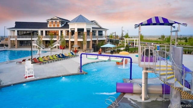7000 S White Crow Way, Aurora, CO 80016 - pool at dusk featuring a water play area, a patio, and a community pool