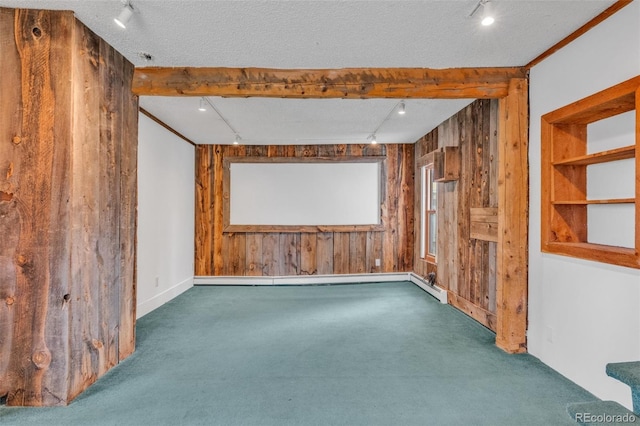 empty room with a textured ceiling, wood walls, and dark colored carpet