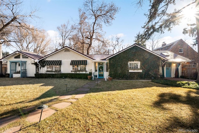 ranch-style house featuring metal roof and a front lawn