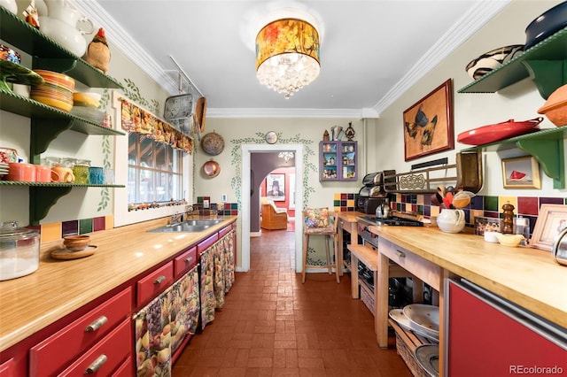 kitchen with brick floor, open shelves, ornamental molding, a sink, and butcher block countertops