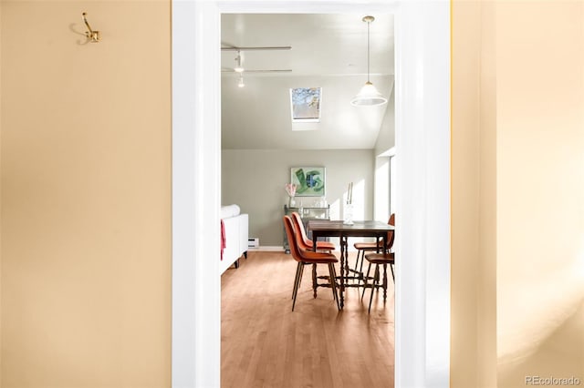 dining room with vaulted ceiling, baseboards, and wood finished floors