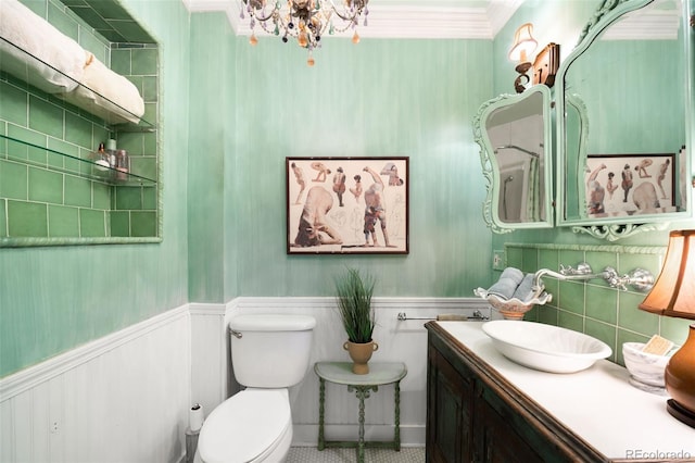 bathroom with wainscoting, vanity, toilet, and a notable chandelier