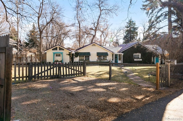 exterior space with a fenced front yard and a gate