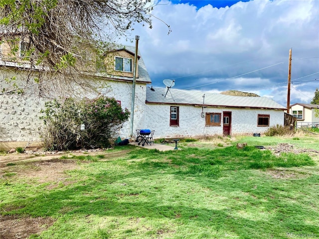 941 French St, Silver Cliff, CO 81252 - back of property featuring a lawn, a patio area, and stucco siding