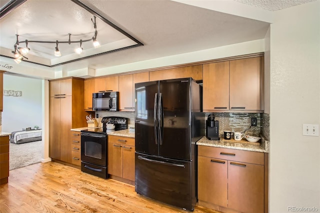 12013 W 56th Cir, Arvada, CO 80002 - kitchen with black appliances, light wood-style floors, tasteful backsplash, light stone counters, and a textured ceiling